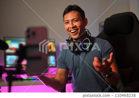 Attractive male gamer talking to audience during live streaming at gaming room 110468238