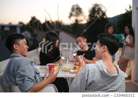 Group of friends hanging out together talking and having fun on a rooftop party Group of friends hanging out together talking and having fun on a rooftop party 110468331