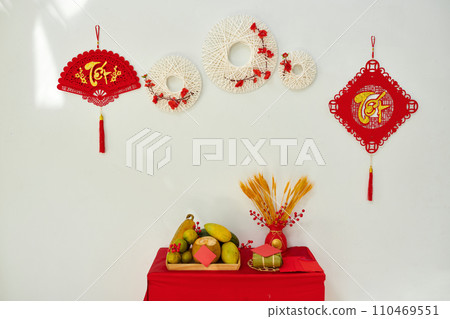 Vietnamese lunar new year decorations with ornaments hanging on wall and table with fresh fruits Vietnamese lunar new year decorations with ornaments hanging on wall and table with fresh fruits 110469551
