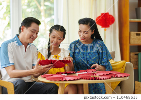Happy parents making spring festival decorations with daughter at home Happy parents making spring festival decorations with daughter at home 110469613