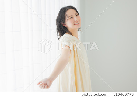 一位年輕女子沐浴在早晨的陽光下 110469776