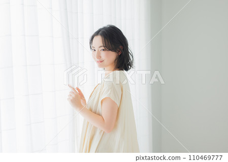 一位年輕女子沐浴在早晨的陽光下 110469777