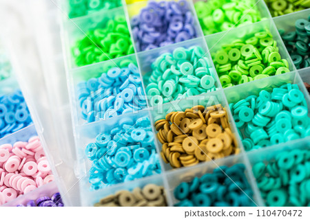 Assorted clay bead boxes neatly arranged on a white table, awaiting a creative kids' craft project. Assorted clay bead boxes neatly arranged on a white table, awaiting a creative kids' craft project. 110470472
