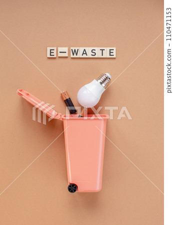 LED bulb and batteries in the trash can. Garbage sorting concept. 110471153