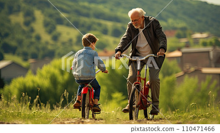 grandfather teaches grandson to ride a bike 110471466