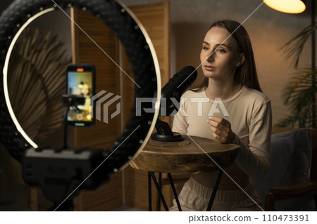 Brunette blogger woman records a live video on her home studio. A fun conversation with a youtuber, tips, a review of hobbies in the media Brunette blogger woman records a live video on her home studio. A fun conversation with a youtuber, tips, a review of hobbies in the media 110473391