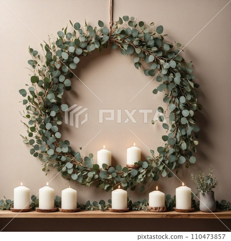 Christmas eucalyptus wreath with white candles on a beige home wall 110473857