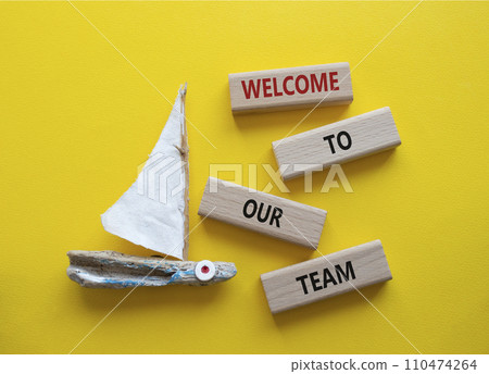 Welcome to our team symbol. Concept words Welcome to our team on wooden blocks. Beautiful yellow background with boat. Business and Welcome to our team concept. Copy space. 110474264