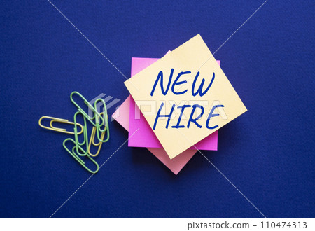New Hire symbol. Orange steaky note with concept words New Hire. Beautiful deep blue background. Business and New Hire concept. Copy space. 110474313