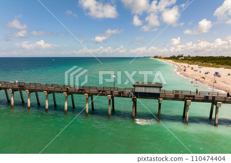 Summer landscape at Venice fishing pier in Florida. Ocean surf waves crashing on warm sandy beach Summer landscape at Venice fishing pier in Florida. Ocean surf waves crashing on warm sandy beach 110474404