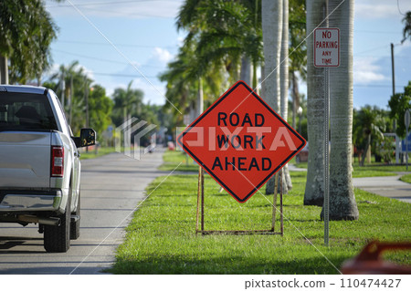 Road work ahead sign on street site as warning to cars about construction and utility works Road work ahead sign on street site as warning to cars about construction and utility works 110474427
