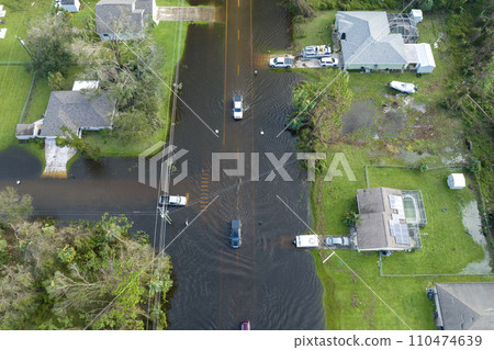 Hurricahe fainfall flooded Florida road with evacuating cars and surrounded with water houses in suburban residential area Hurricahe fainfall flooded Florida road with evacuating cars and surrounded with water houses in suburban residential area 110474639