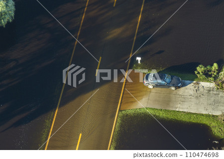 Flooded american street in Florida residential area. Hazardous driving conditions. Consequences of hurricane natural disaster Flooded american street in Florida residential area. Hazardous driving conditions. Consequences of hurricane natural disaster 110474698