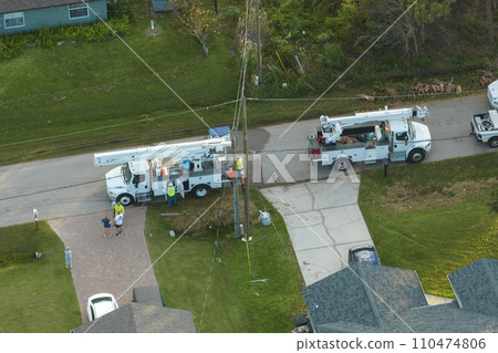 Electrical service company restoring power repairing damaged power lines after hurricane Idalia in Florida suburban area 110474806