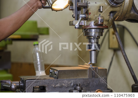 The NC milling machine face milling the metal parts. 110475903