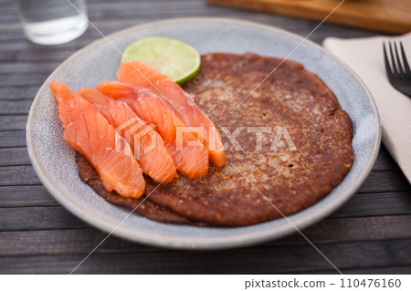 Salted salmon fillet with buckwheat pancakes and lime Salted salmon fillet with buckwheat pancakes and lime 110476160