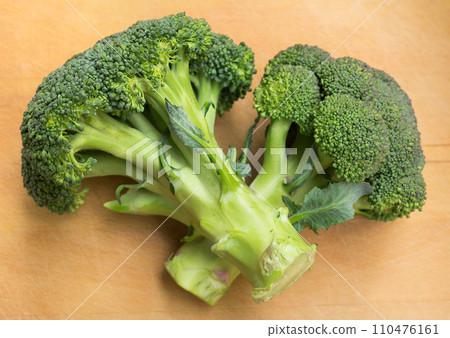 Healthy broccoli and florets on wooden board Healthy broccoli and florets on wooden board 110476161