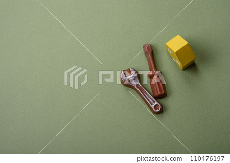Repair or home improvement tools and a house model on a plain background Repair or home improvement tools and a house model on a plain background 110476197