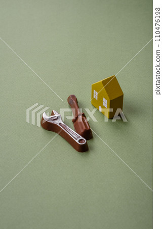 Repair or home improvement tools and a house model on a plain background Repair or home improvement tools and a house model on a plain background 110476198