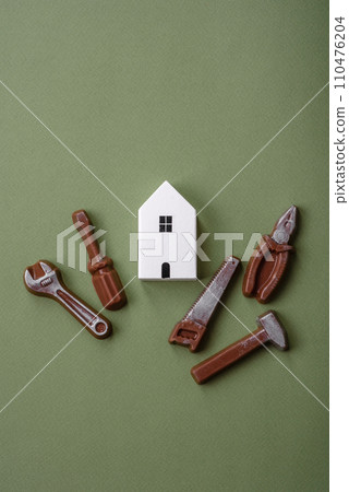 Repair or home improvement tools and a house model on a plain background Repair or home improvement tools and a house model on a plain background 110476204