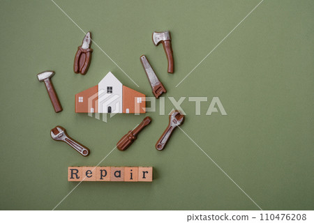 Repair or home improvement tools and a house model on a plain background Repair or home improvement tools and a house model on a plain background 110476208