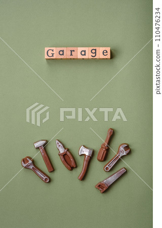 Tools and inscriptions symbolizing repairs or a garage and its attributes on a plain background 110476234