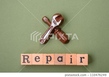 Tools and inscriptions symbolizing repairs or a garage and its attributes on a plain background Tools and inscriptions symbolizing repairs or a garage and its attributes on a plain background 110476249