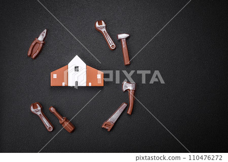 Repair or home improvement tools and a house model on a plain background Repair or home improvement tools and a house model on a plain background 110476272
