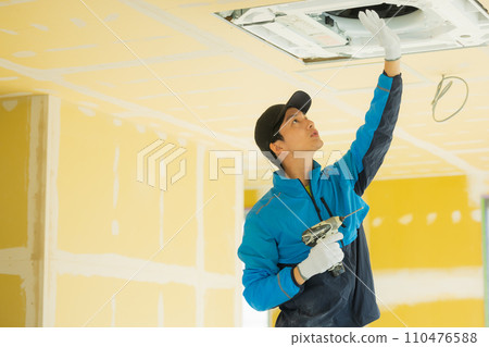 Workers inspecting air conditioners 110476588