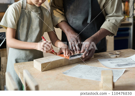 Closeup of unrecognizable carpenter teaching little girl woodworking in crafts school for children Closeup of unrecognizable carpenter teaching little girl woodworking in crafts school for children 110476830