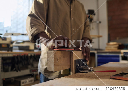 Close up of unrecognizable senior craftsman polishing wood building furniture in sunlit workshop Close up of unrecognizable senior craftsman polishing wood building furniture in sunlit workshop 110476858