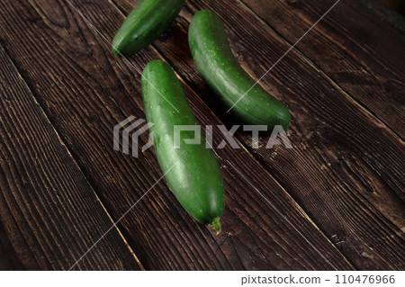 Dark green whole raw cucumbers on old rustic wooden table Dark green whole raw cucumbers on old rustic wooden table 110476966