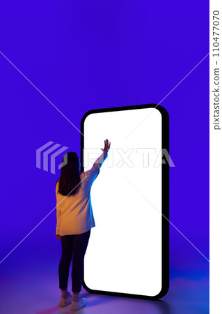 Woman confidently interacting with phone, showcasing classic touch gesture, with empty screen. Suitable for technology product advertisements. Woman confidently interacting with phone, showcasing classic touch gesture, with empty screen. Suitable for technology product advertisements. 110477070