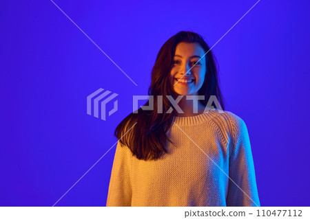 Eye Contact. Portrait of young girl looks directly at camera, establishing strong connection with viewer against gradient blue background. Eye Contact. Portrait of young girl looks directly at camera, establishing strong connection with viewer against gradient blue background. 110477112