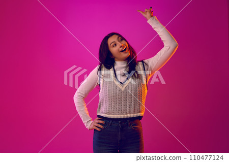 Pointing to Future. Portrait of girl pointing her finger forward and upward, as if directing attention to bright future, solutions to issues raised. 110477124