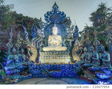 Praying monks and Buddha statues at Wat Rong Suea Ten Blue temple, Chiang Rai, Thailand 110477954