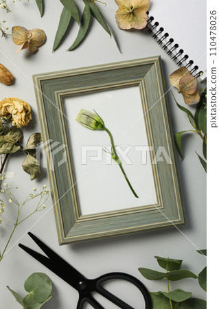 Fresh and dried plants, photo frame, scissors and notepad on light background, top view 110478026
