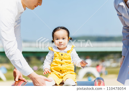 Parent and child playing on the slide of the park 110478054
