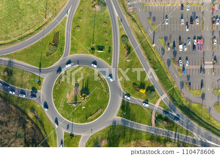 Aerial view of road roundabout intersection with moving heavy traffic. Urban circular transportation crossroads Aerial view of road roundabout intersection with moving heavy traffic. Urban circular transportation crossroads 110478606