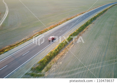 Aerial view of intercity road with blurred fast driving car at sunset. Top view from drone of highway traffic in evening 110478637