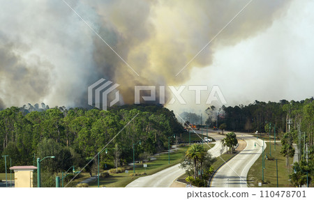 Aerial view of fire department firetrucks extinguishing wildfire burning severely in Florida jungle woods. Emergency service firemen trying to put down flames in forest Aerial view of fire department firetrucks extinguishing wildfire burning severely in Florida jungle woods. Emergency service firemen trying to put down flames in forest 110478701