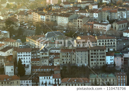 Aerial view of dense historic center of Thiers town in Puy-de-Dome department, Auvergne-Rhone-Alpes region in France. Rooftops of old buildings and narrow streets at sunset 110478706