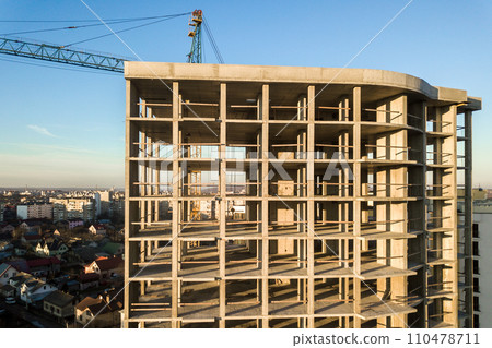 Aerial view of concrete frame of tall apartment building under construction in a city. Aerial view of concrete frame of tall apartment building under construction in a city. 110478711
