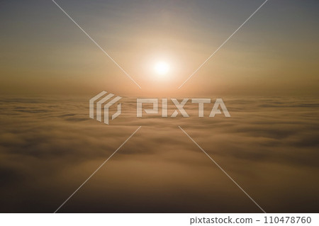 Aerial view from airplane window at high altitude of dense puffy cumulus clouds flying in evening 110478760