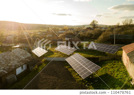 Aerial top down view of solar panels in green rural village yard. 110478761