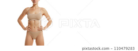 Cropped image of muscular, slim, relief female body. Model posing in underwear against white studio background Cropped image of muscular, slim, relief female body. Model posing in underwear against white studio background 110479283
