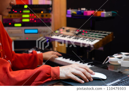 asian professional music producer, composer, arranger, songwriter arranging a hit song on computer in home recording studio. music production concept asian professional music producer, composer, arranger, songwriter arranging a hit song on computer in home recording studio. music production concept 110479303