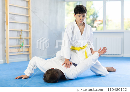 Man and teenage boy train judo fighting techniques 110480122
