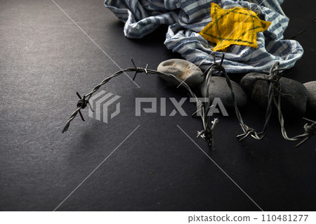 Jewish prisoner with yellow badge on dark background. International Holocaust Remembrance Day Jewish prisoner with yellow badge on dark background. International Holocaust Remembrance Day 110481277