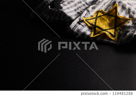 Holocaust memory day. Arbed wire and burning candle on black background 110481288